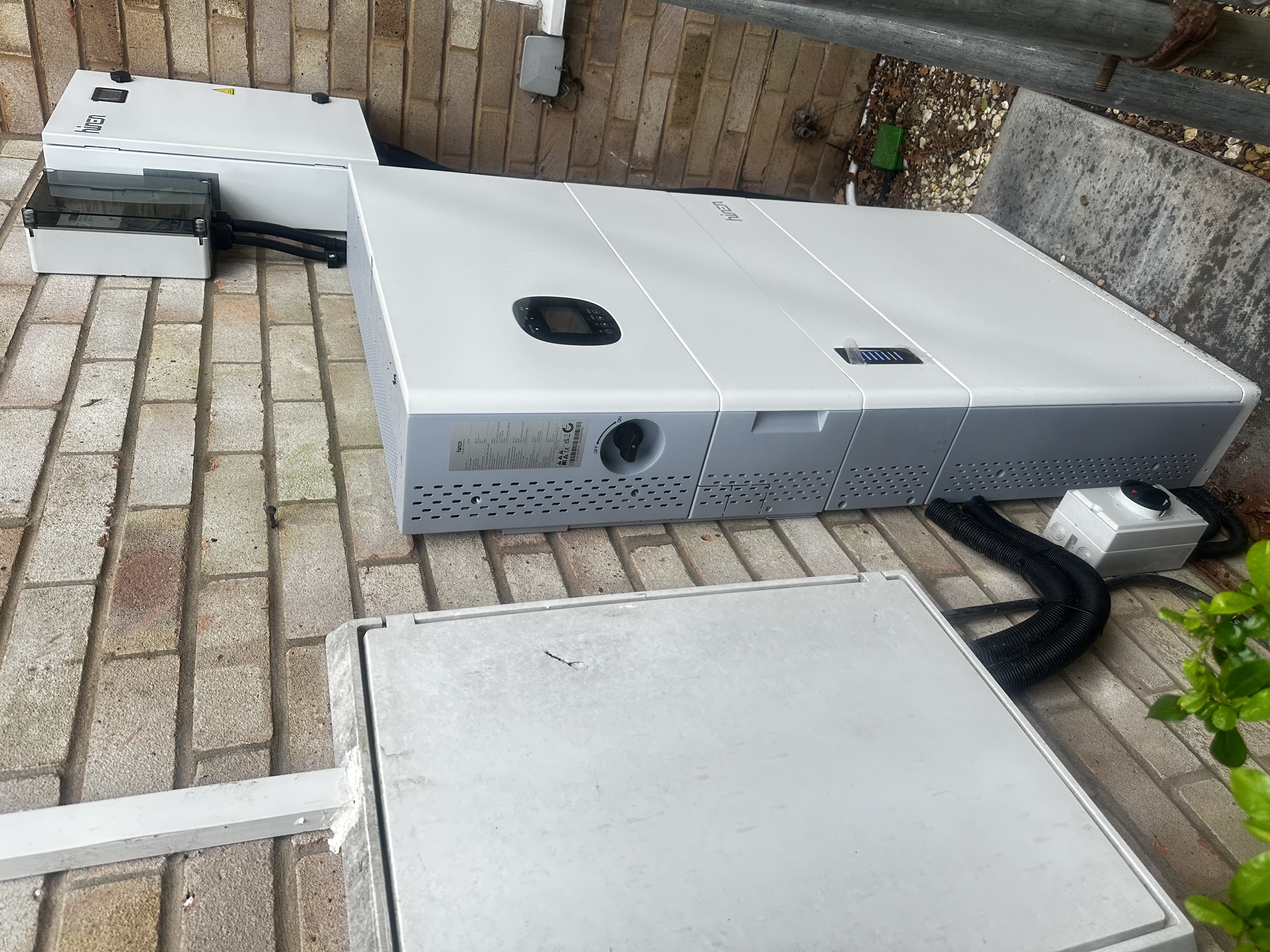 External Hinen battery system installed beside a brick wall
