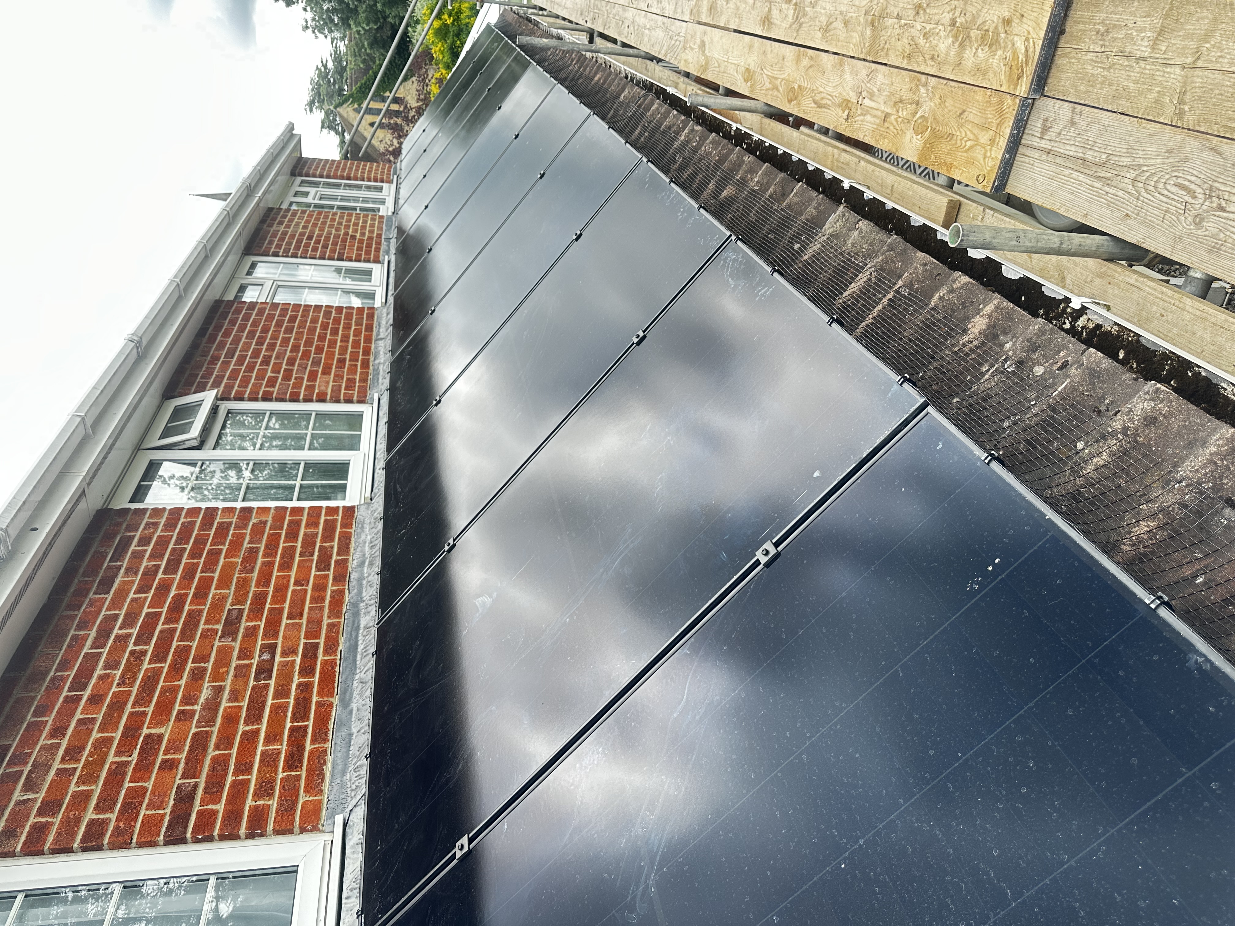 Solar panel array fitted between chimneys on a tiled roof