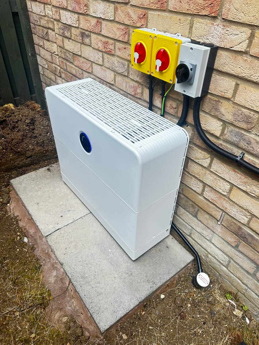 External home battery installation beside a brick wall