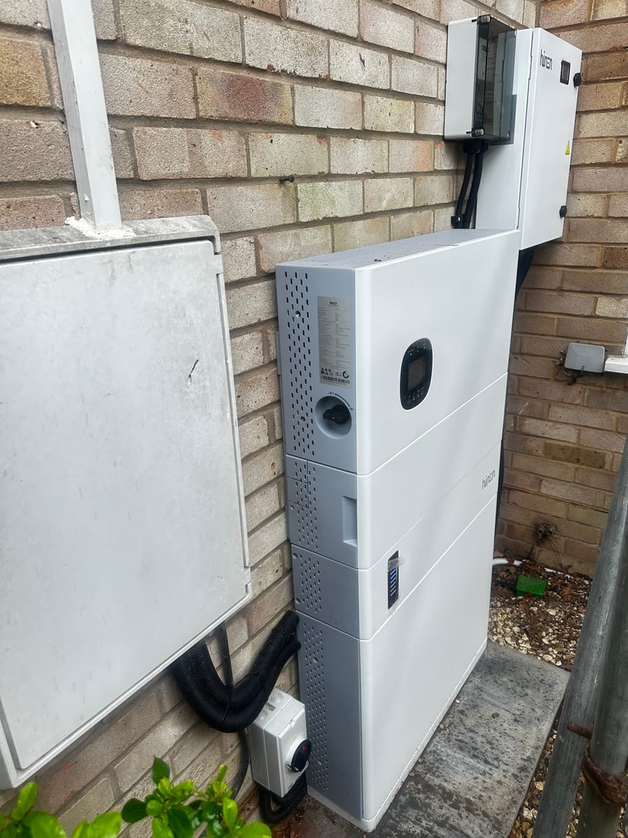 External Hinen battery system installed beside a brick wall