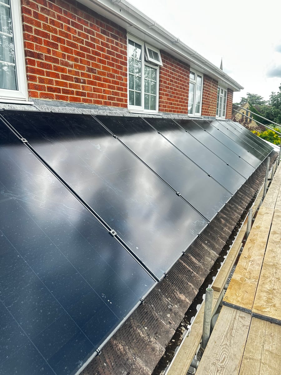 Solar panel array fitted between chimneys on a tiled roof